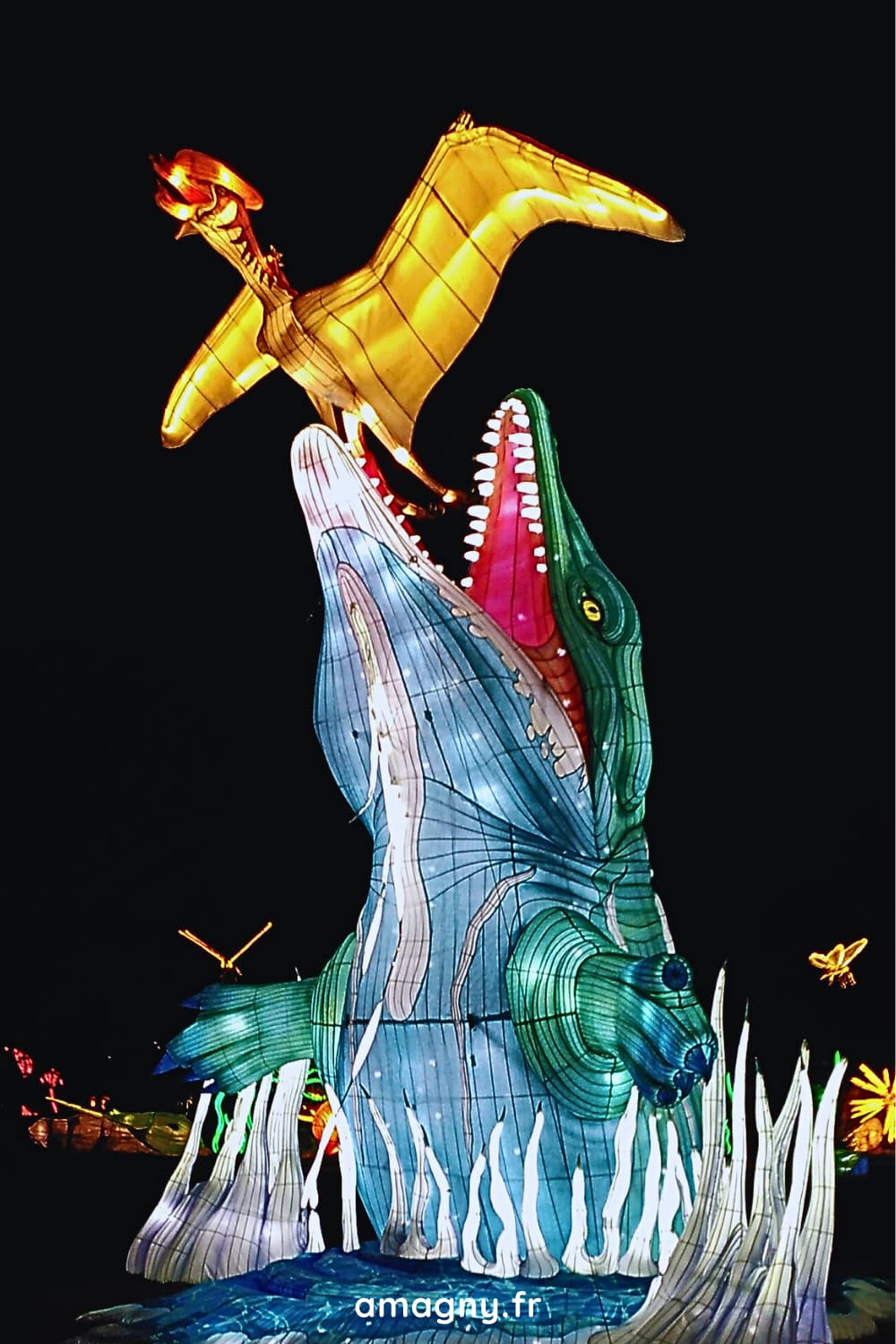 Lanterne lumineuse d’un mosasaure surgissant de l’eau face à un ptérosaure au Muséum d’Histoire naturelle de Paris.