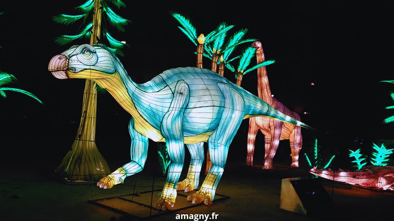 Lanternes lumineuses de dinosaures dans un décor nocturne préhistorique.