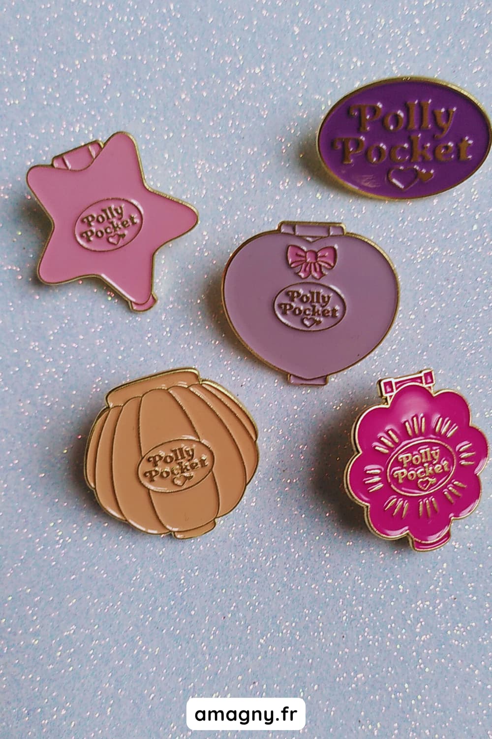 Pin’s émaillés en forme de compacts Polly Pocket sur fond pailleté.
