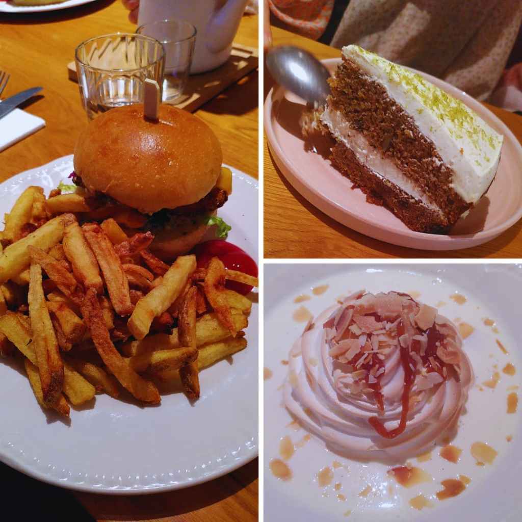 Assiettes de burger, gâteau et dessert meringué sur table en bois.