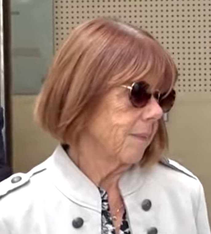 Portrait de Gisèle Pelicot, cheveux cuivrés au carré et lunettes rondes.