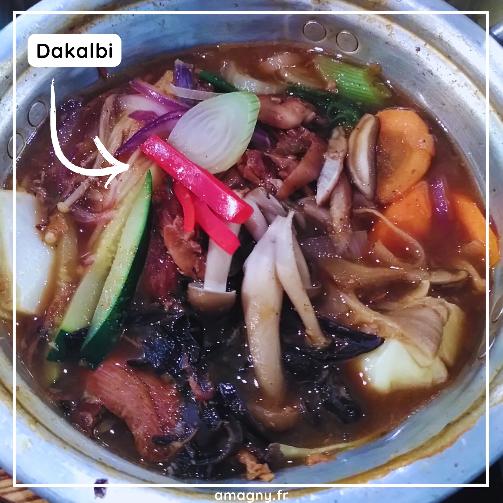 Marmite de dakgalbi coréen avec poulet, légumes variés et sauce épicée en train de mijoter.