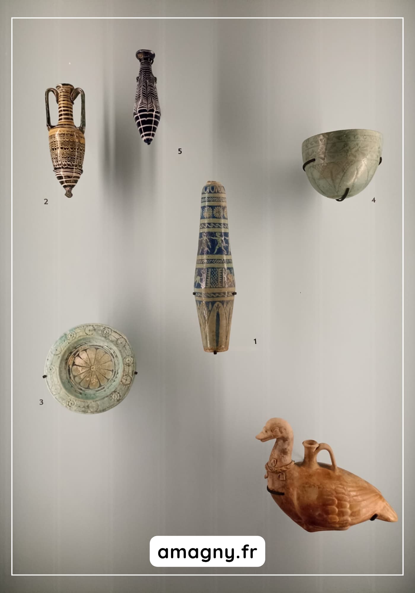 Six céramiques anciennes exposées en vitrine, comprenant vases, bols et récipient zoomorphe.