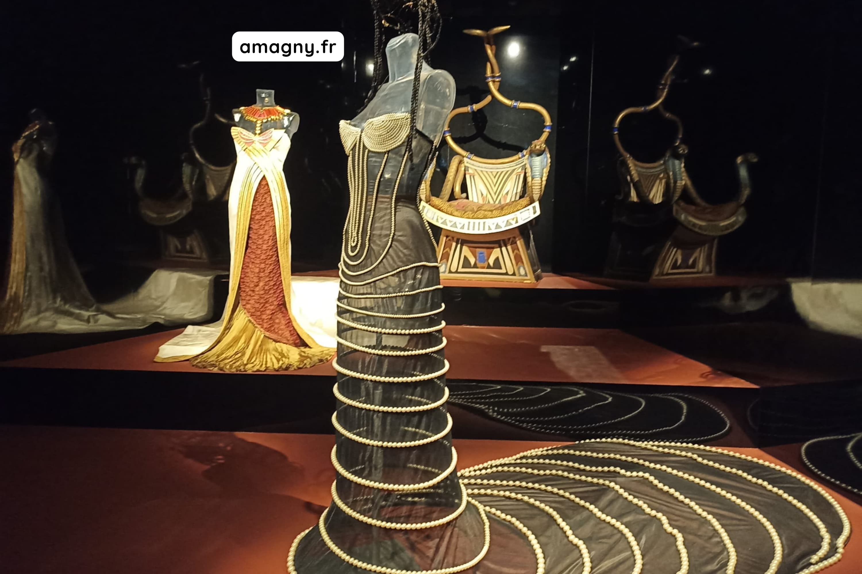 Robe noire ornée de perles portée par Monica Bellucci dans Mission Cléopâtre, exposée en musée.
