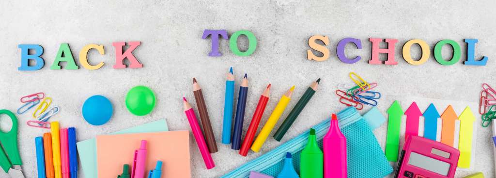 Fournitures scolaires colorĂ©es disposĂ©es sous les lettres multicolores formant lâexpression Back to School.