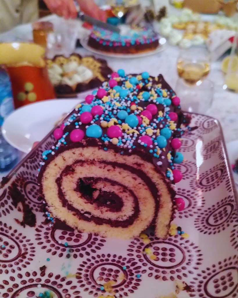 Bûche roulée au chocolat décorée de vermicelles.