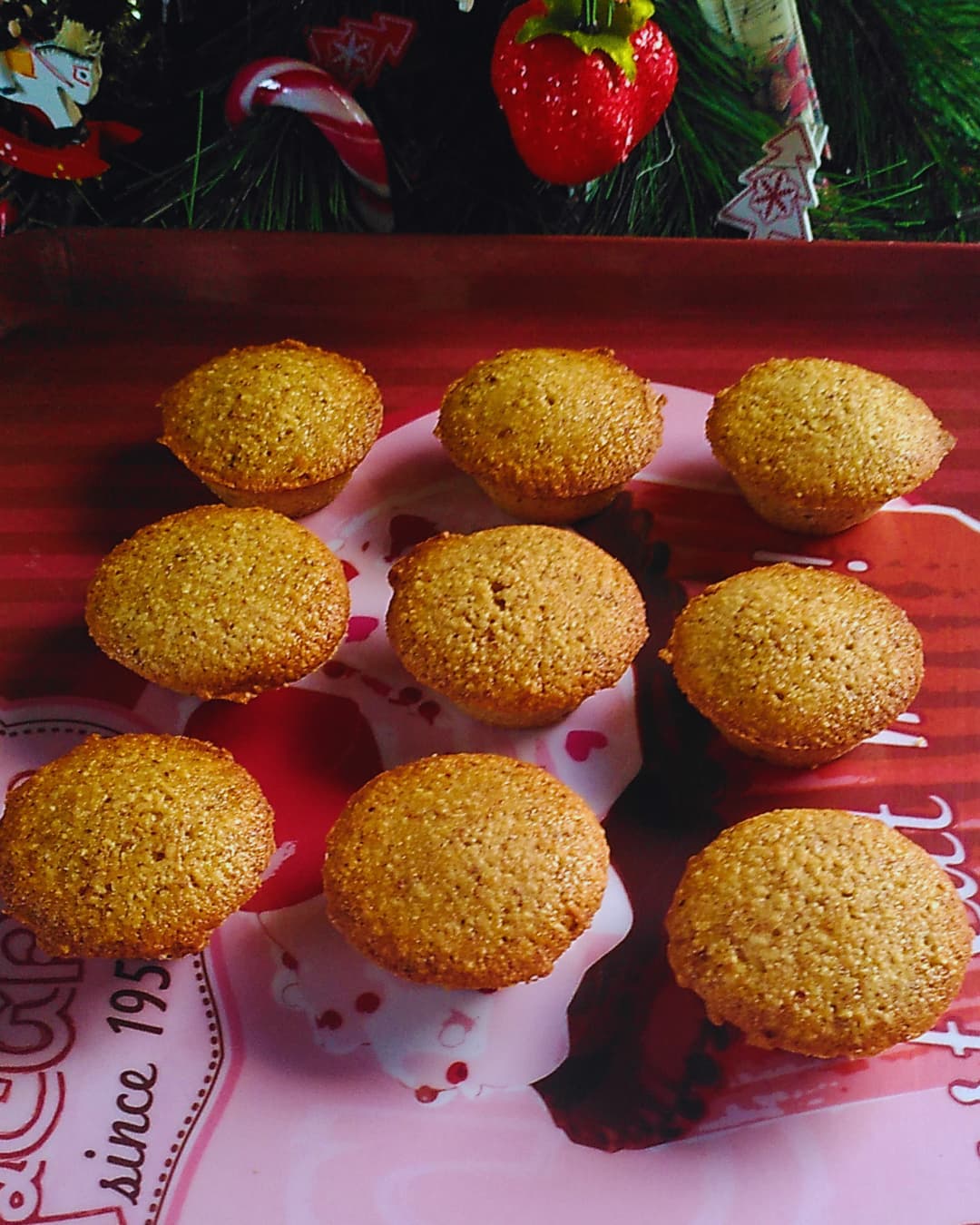 Plateau de biscuits dorés à la noisette, disposés en rangs sur fond festif.