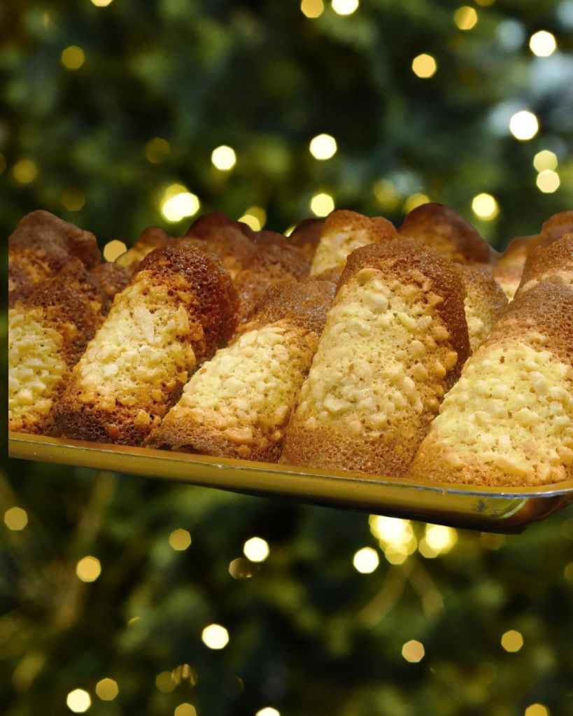 Tuiles dorées aux amandes effilées, alignées sur un plateau en ambiance festive.