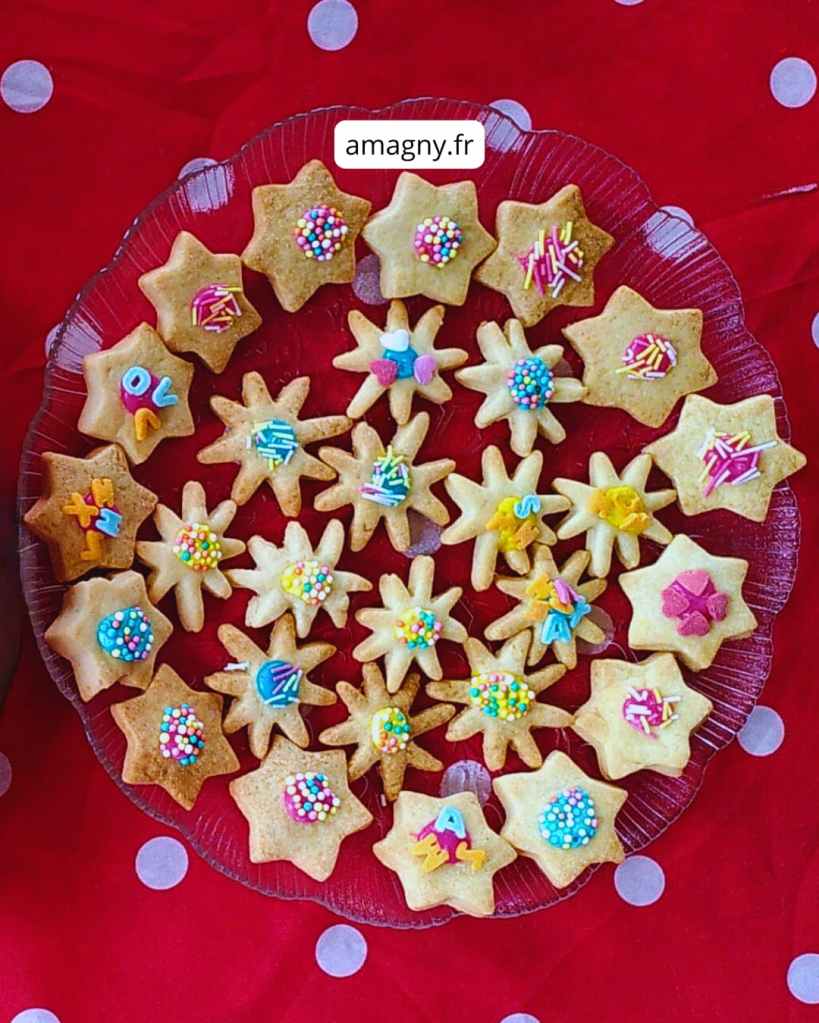 Assiette de sablés en étoile décorés de glaçage, lettres en sucre et vermicelles colorés. 