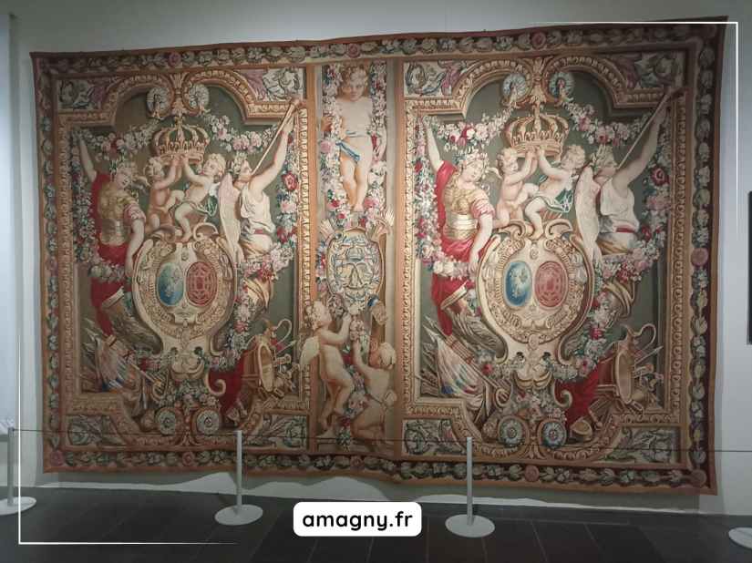 Tapisserie ancienne aux médaillons couronnés, ornée de figures classiques, de chérubins et de motifs floraux, exposée au château de Sceaux.