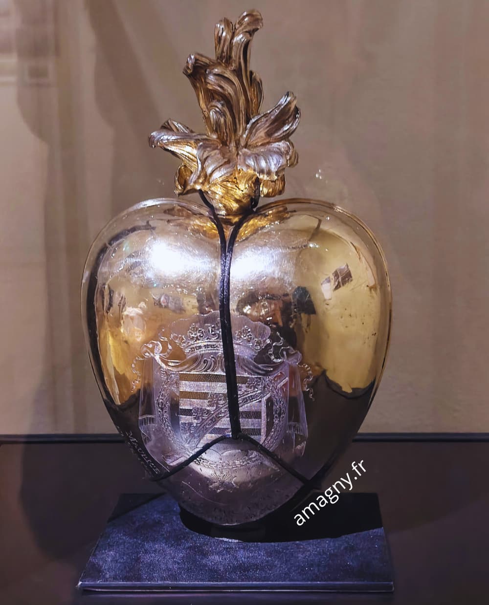 Objet en forme de cœur métallique exposé au Musée de l’Homme, présenté dans une vitrine comme pièce rituelle ou historique.