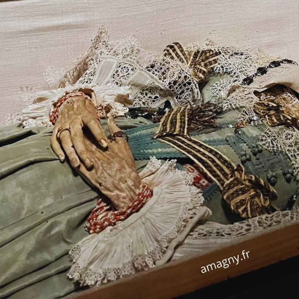 Gros plan sur la momie dite “jeune fille de Strasbourg”, montrant ses vêtements conservés et les détails de sa présentation muséale.